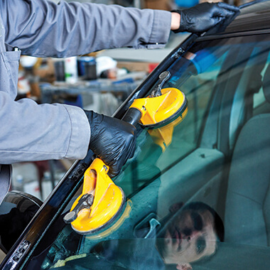 Glass repair worker working in automotive setting